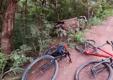 Carro capota em curva, atinge ciclista e dois ficam feridos